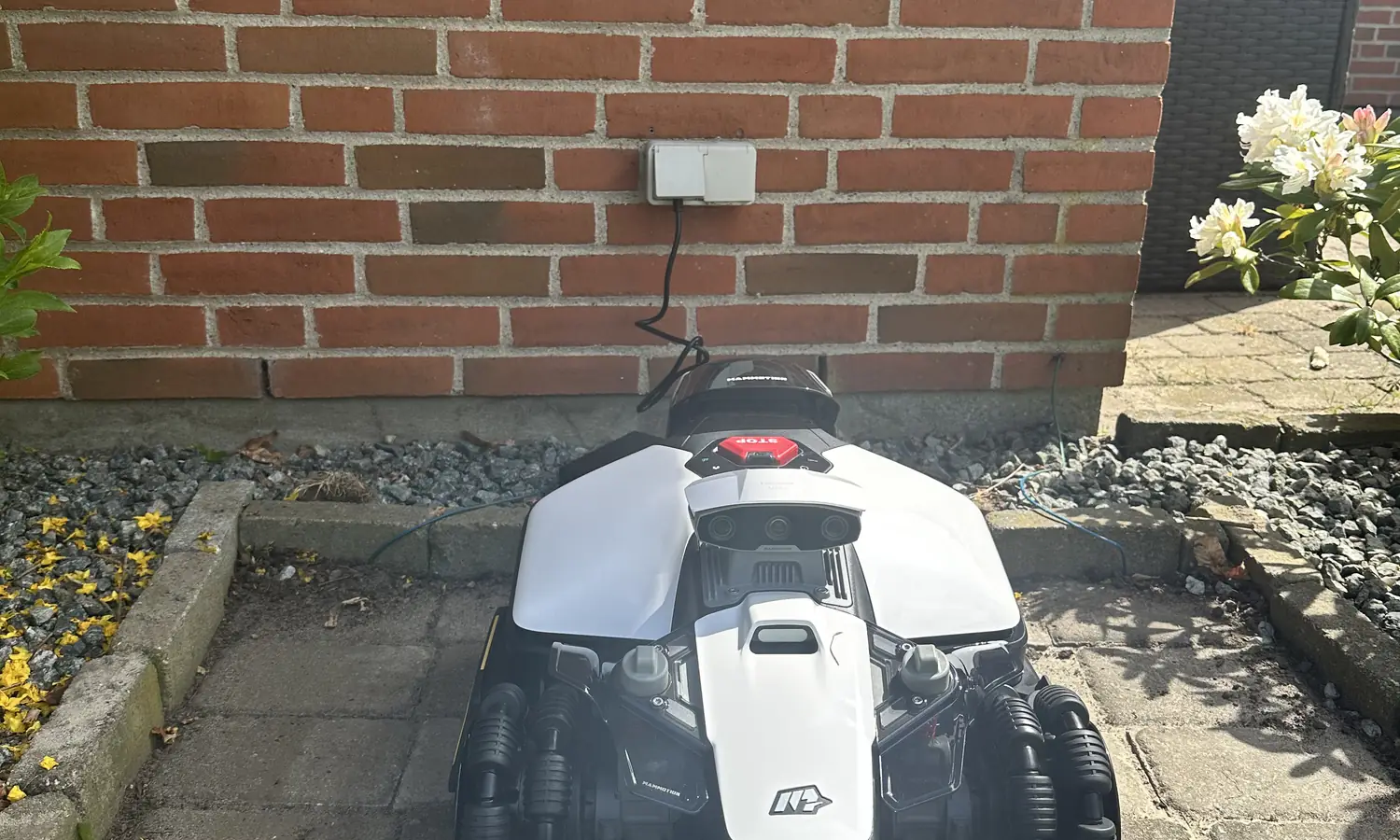 Ladestation og robotplaeneklipper monteret ved hus